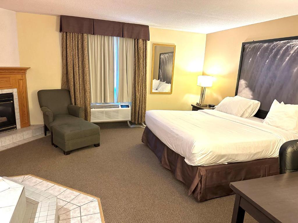 a hotel room with a bed and a chair at Super 8 by Wyndham Niagara Falls by the Falls in Niagara Falls
