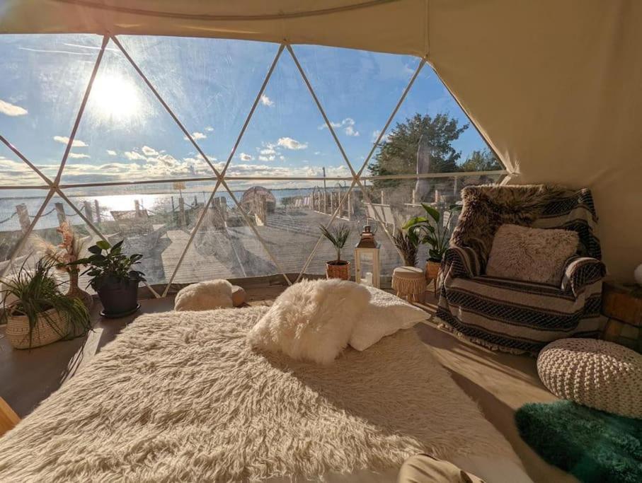 a room with a large window with a bed and a chair at beautiful located dome in Wapnica