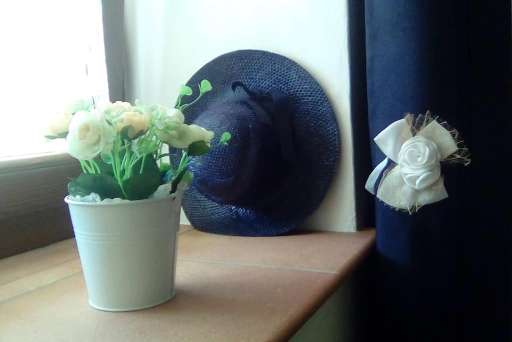 un jarrón de flores en un estante con un sombrero en Casa&Cantina, en Senise
