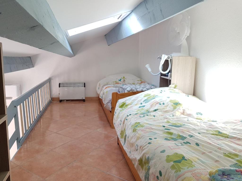 sypialnia z 2 łóżkami i schodami w obiekcie Petit pavillon St Pierre w mieście Saint Pierre La Mer