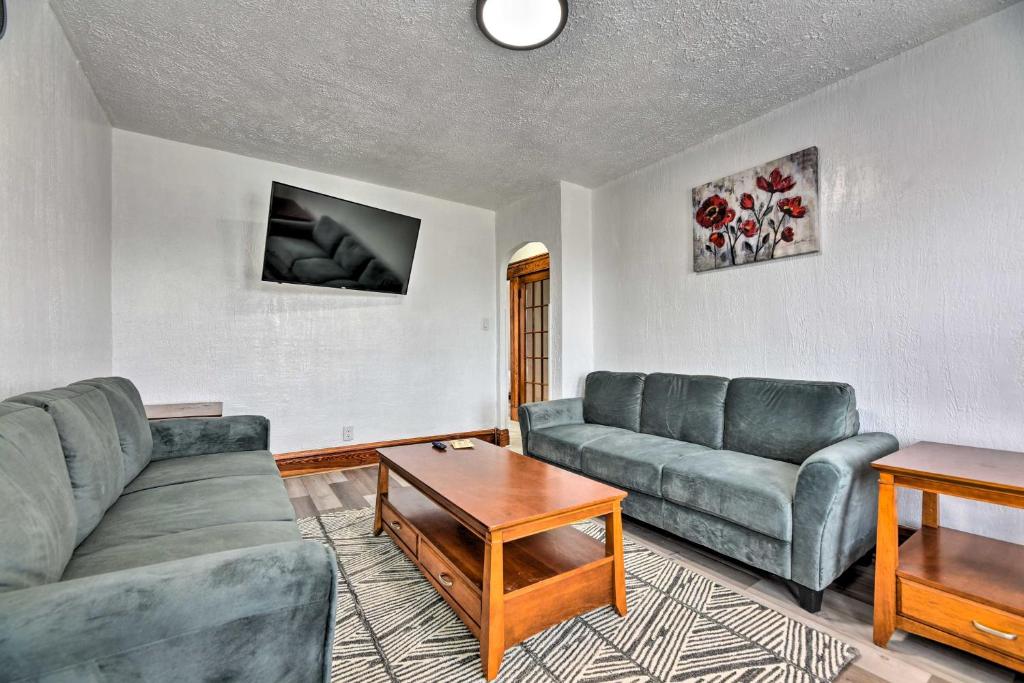 a living room with two couches and a table at Vacation Rental about 2 Mi to Highmark Stadium! in Buffalo