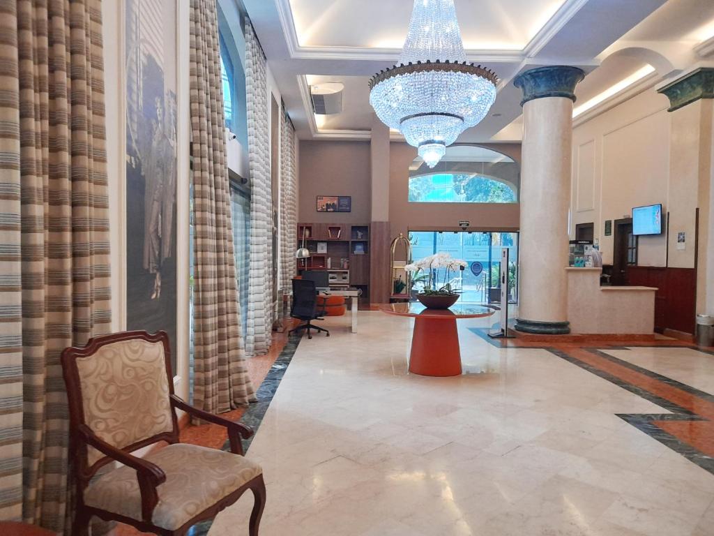 a lobby with a chandelier and a chair in a building at Flat IMPECAVEL proximo aos Shoppings JK e Vila Olimpia in Sao Paulo