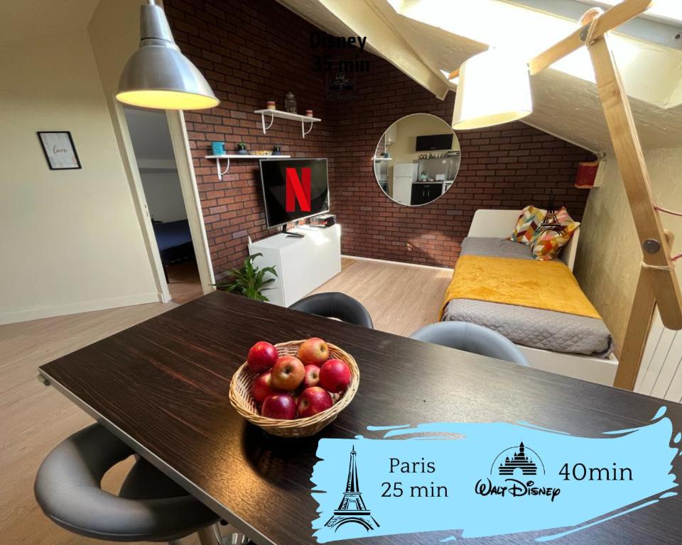a table with a bowl of fruit on it in a room at Duplex Cosy et Familial in Fontenay-sous-Bois