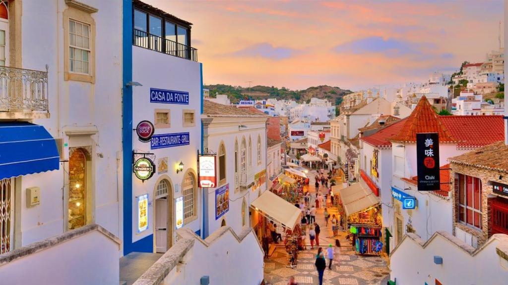 uitzicht op een straat in een stad bij zonsondergang bij Prime Lux Albufeira in Albufeira