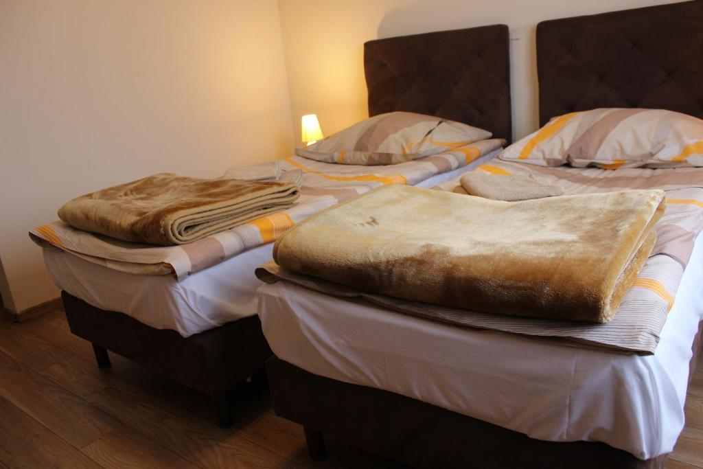 two beds with blankets on them in a room at Dom Pielgrzyma in Toruń