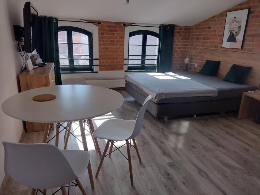 um quarto com uma cama, uma mesa e cadeiras em 13 Starówka apartament Miodova em Toruń
