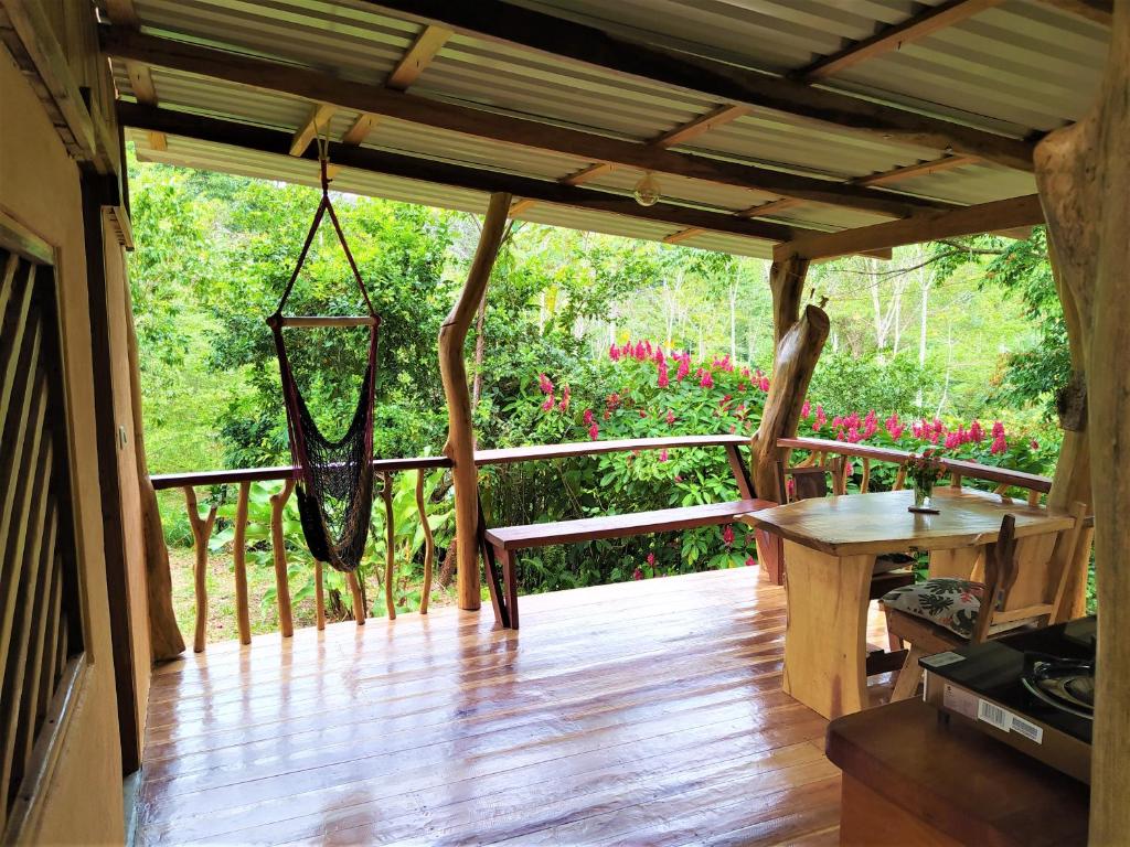 a porch with a hammock on a wooden deck at Terra NaturaMa - off grid living in the jungle in Punta Uva