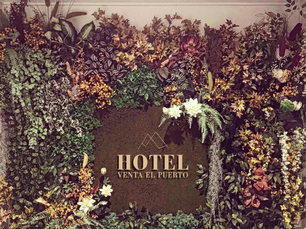 a sign that is covered in plants and flowers at Hotel Venta El Puerto in Murcia