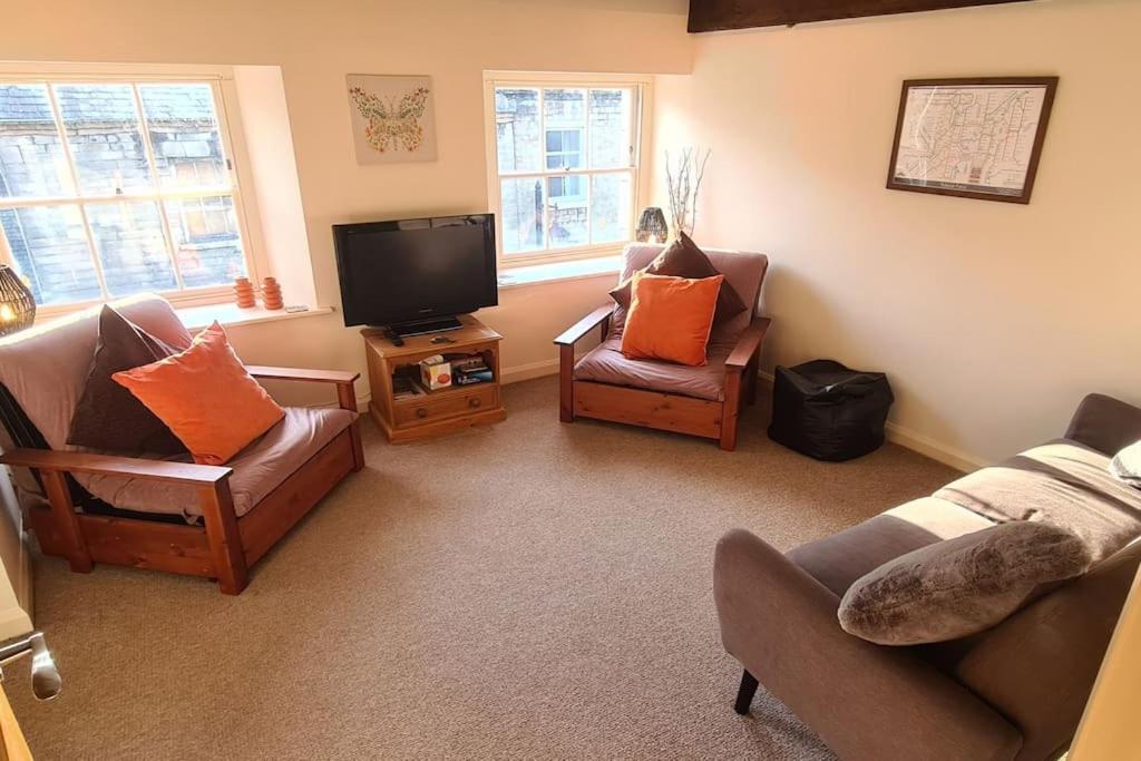 a living room with two chairs and a television at Lovely 2 bedroom apartment in Kendal town centre in Kendal