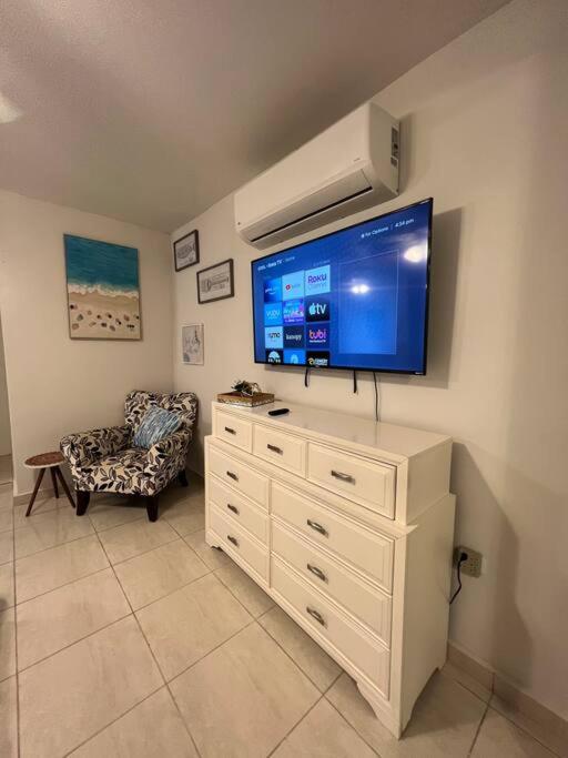 a living room with a flat screen tv on a wall at Playa y Campo Studio in Isabela