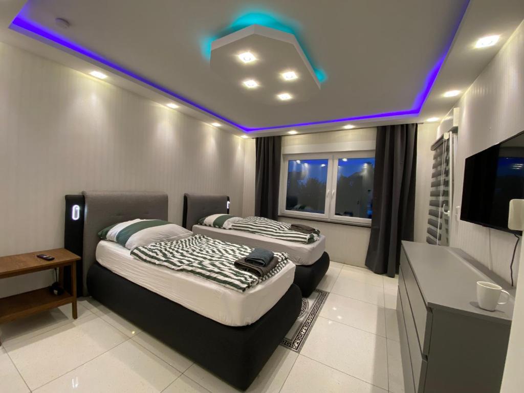 エッセンにあるAparts House - Balkon-WiFi-Kitchenのテレビ付きの客室で、ベッド2台が備わります。