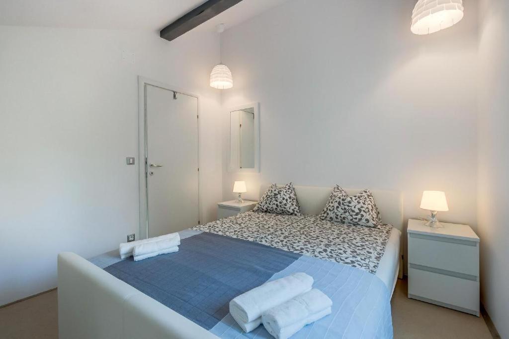 a white bedroom with a blue bed with two pillows at Laguna in Nerezine