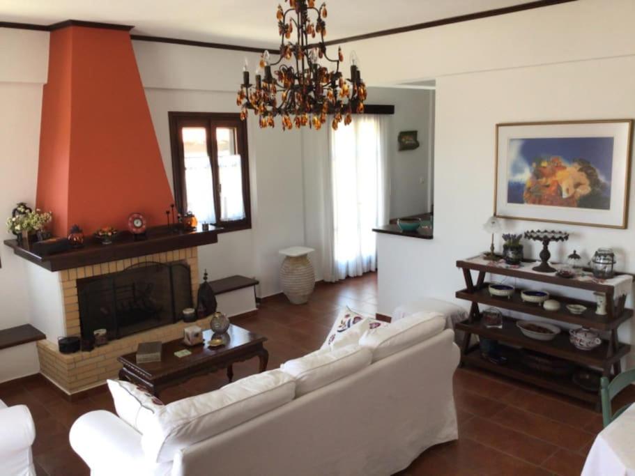a living room with a white couch and a fireplace at An all comforts home in Koroni