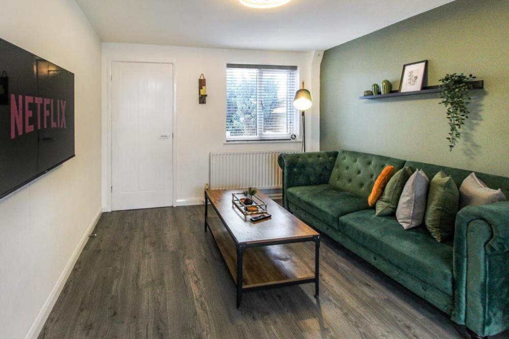 a living room with a green couch and a coffee table at 2 Bed Townhouse with Free Parking in Nottingham