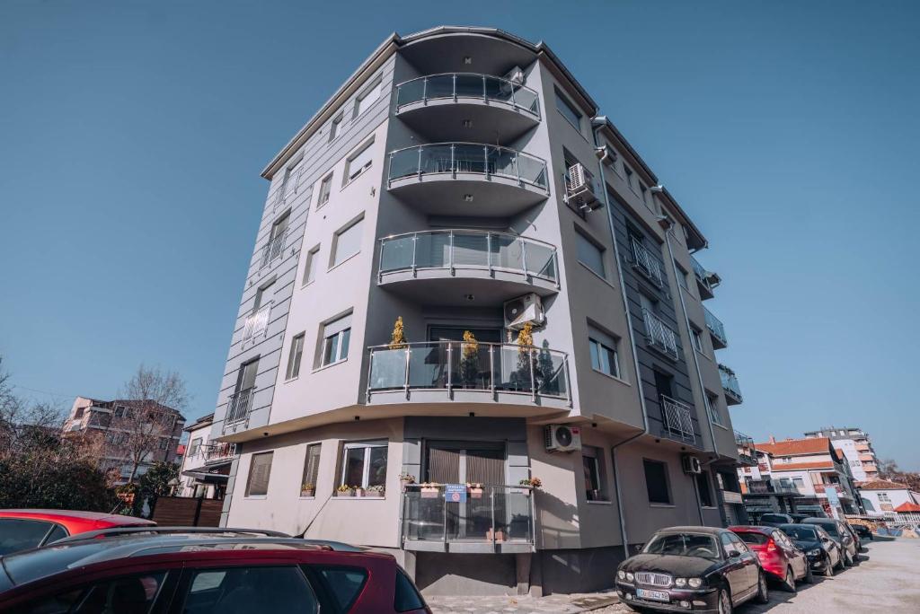un edificio alto con coches estacionados frente a él en Darki Apartments 4 - Very Central 100 Square Meters,Two Bedrooms,Free Parking en Ohrid
