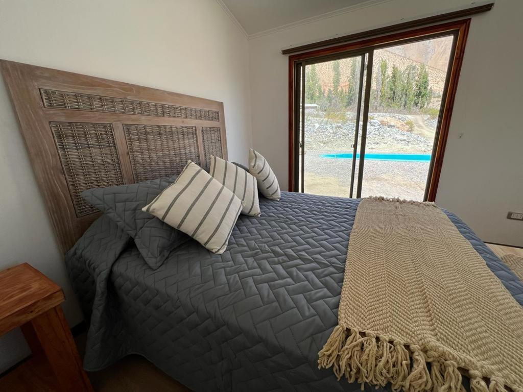 um quarto com uma cama com almofadas e uma janela em Refugio Alma de Montaña, piscina privada em Monte Grande