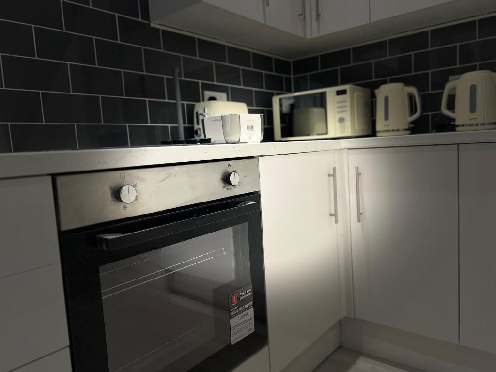a kitchen with a counter with a stove top oven at Regent 28 in Coventry