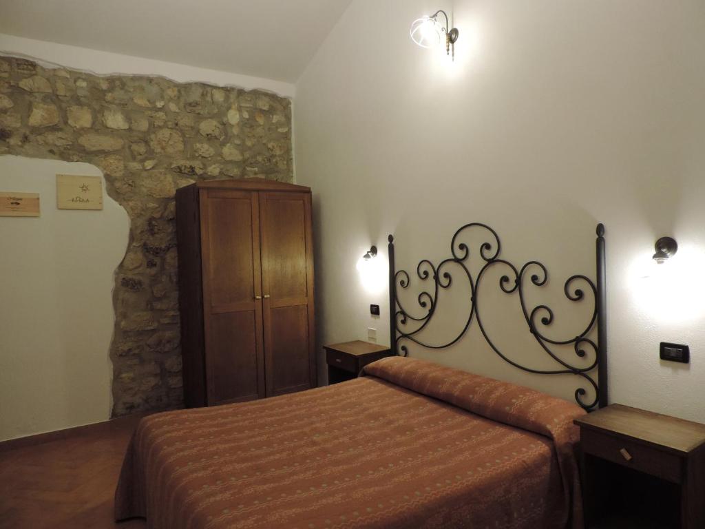 a bedroom with a bed and a wooden cabinet at Tenuta Chianchito in San Giovanni Rotondo