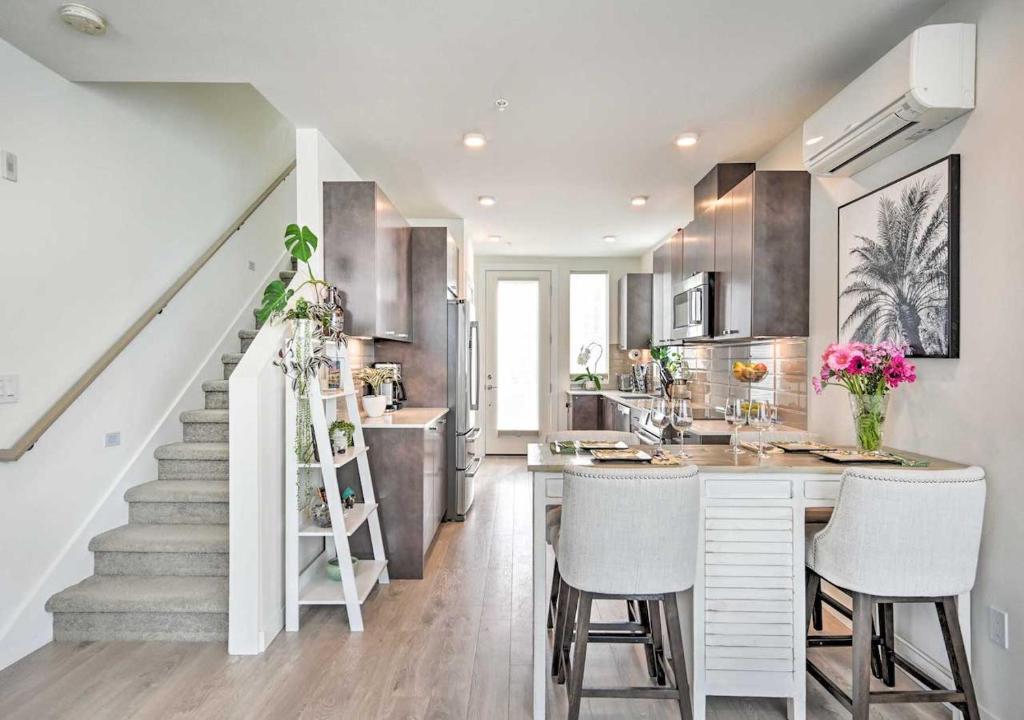 una cocina con escalera y una isla de cocina con taburetes en NEW! Stylish Townhome in Ballard en Seattle