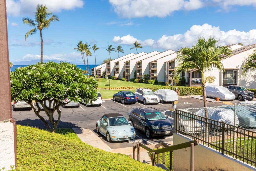 a parking lot with cars parked in front of a building at Hale Kamaole 158 in Wailea