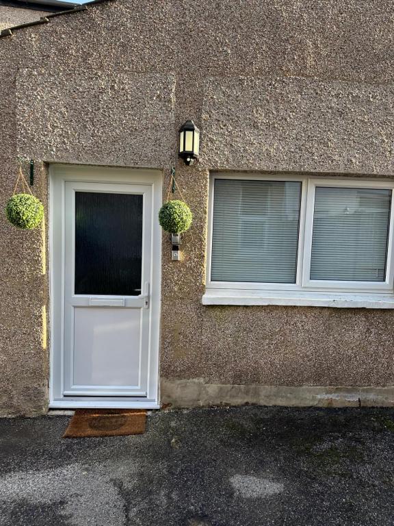 une maison avec une porte blanche et deux fenêtres dans l'établissement Silver Dream, à Southend-on-Sea