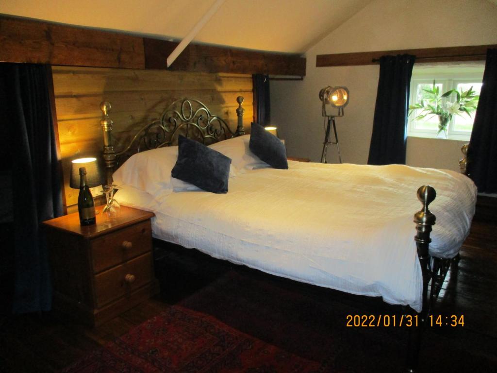 um quarto com uma cama grande e uma janela em Bridge Stores em Fritton Norfolk