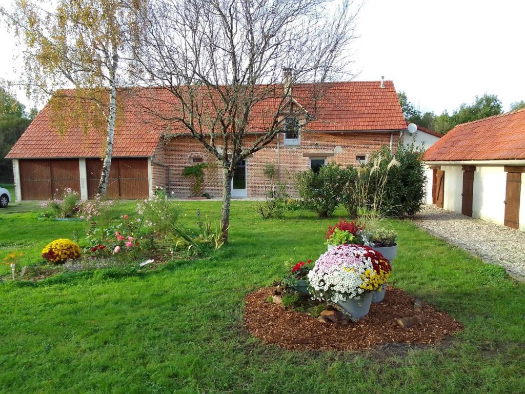 um jardim com flores num quintal com uma casa em Gite Sologne em Marcilly-en-Gault