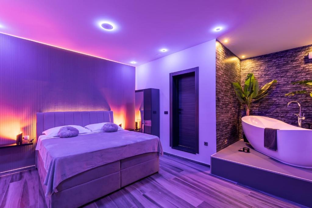 um quarto com uma cama, uma banheira e um lavatório em Luxury room Ekstaza em Solin