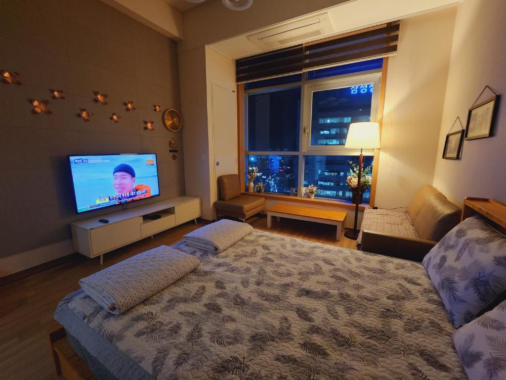 a bedroom with a bed and a flat screen tv at Y stay in Daegu