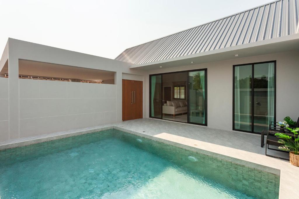 a swimming pool in the backyard of a house at Private Pool Villa Newly-built Vimalai house in Pattaya in Nong Prue