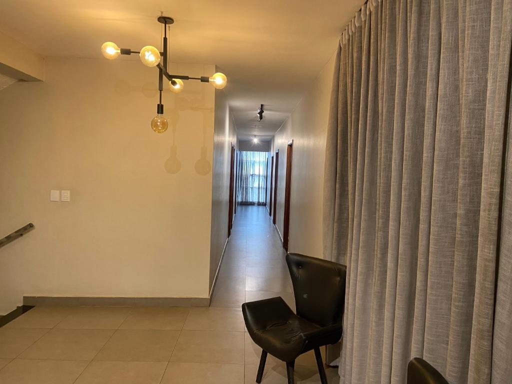 uma sala de estar com uma cadeira e um corredor em El Nassr suits em Goiânia