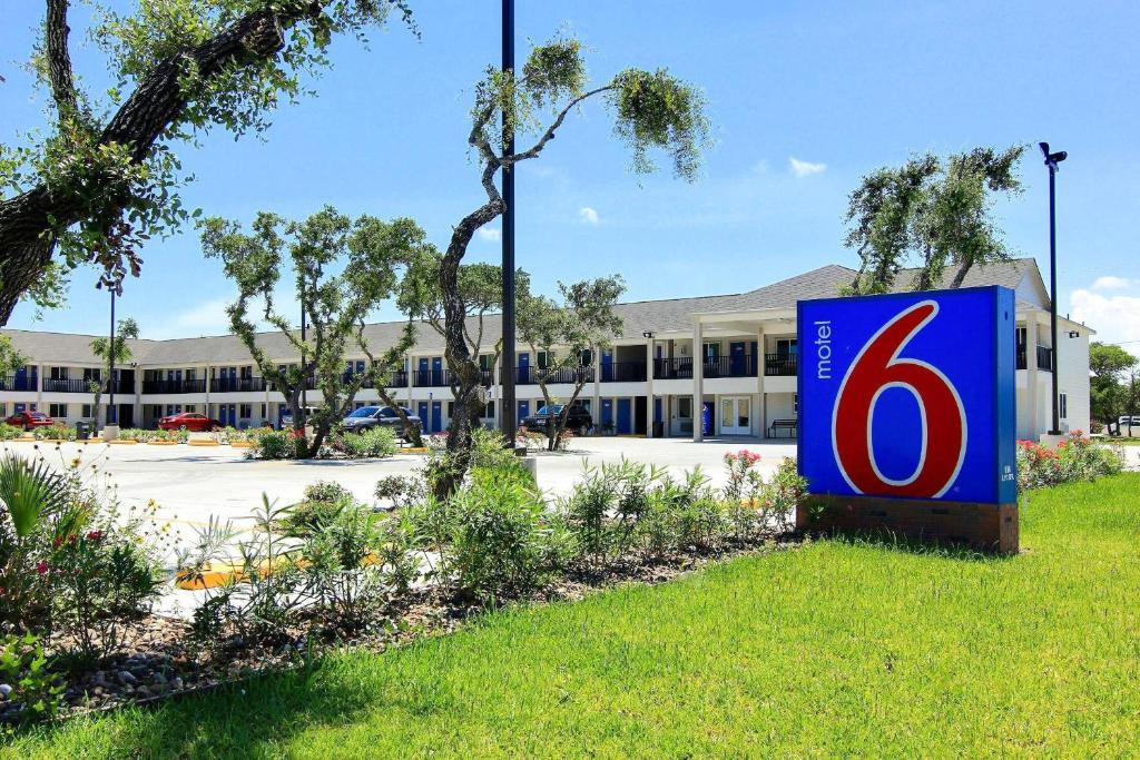 a sign in the grass in front of a building at Motel 6-Rockport, TX in Rockport