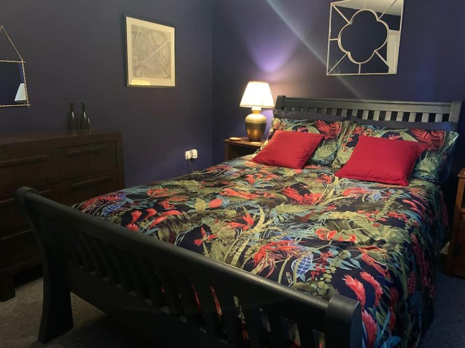 a bed with two red pillows in a bedroom at Gorgeous seaside getaway. in Hastings