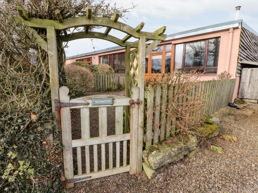 an old gate with an archway in front of a house at Nuthatch in Ivegill