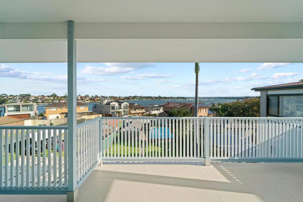 a white balcony with a view of a city at Sky Home - Two Bedroom Loft Townhouse with Bay Views in Sydney