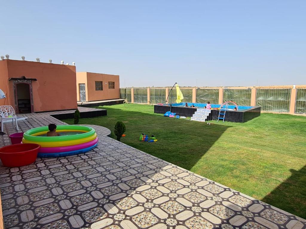 een achtertuin met een zwembad en een speeltuin bij فلة المصري 