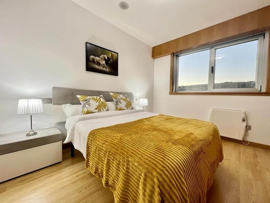 Un dormitorio con una cama grande y una ventana. en Lanús Malpica de Bergantiños-Costa da Morte, en Malpica de Bergantiños