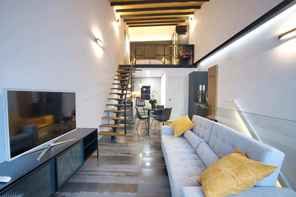 a living room with a couch and a staircase at Cuencaloft Buenavista in Cuenca