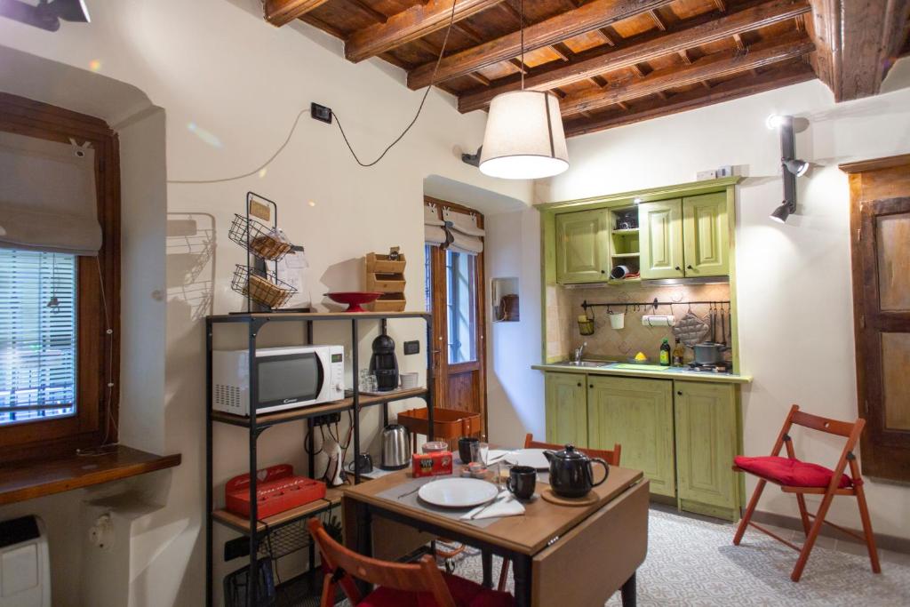トリノにあるCasa Vibrisseのキッチン(緑のキャビネット、テーブル、椅子付)
