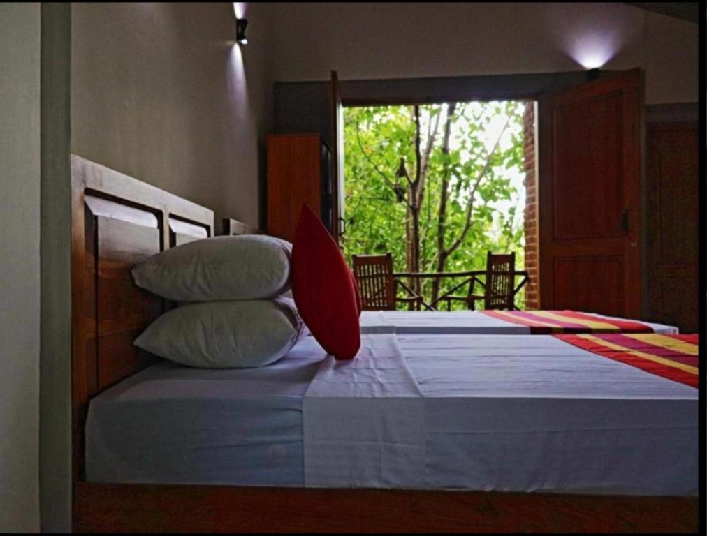 - une chambre avec 2 lits avec des oreillers et une fenêtre dans l'établissement THE HIDEOUT KURUNEGALA, à Kurunegala