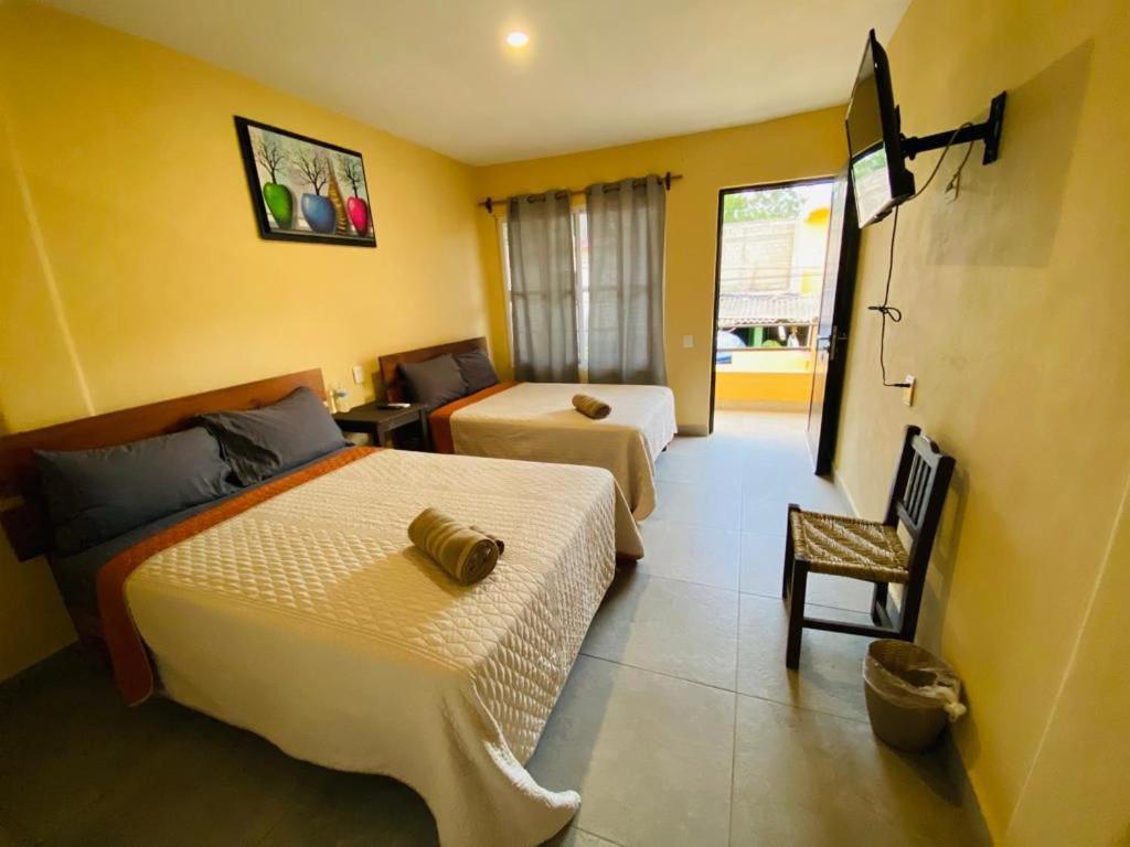una habitación de hotel con 2 camas y una silla en HOTELITO SAN IGNACIO, en San Ignacio