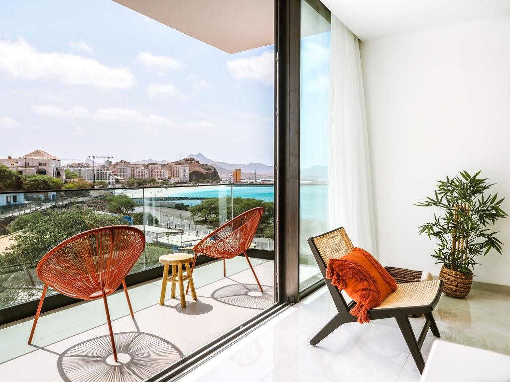 a balcony with chairs and a view of the ocean at Filomena Apartments BOHÈME in Mindelo
