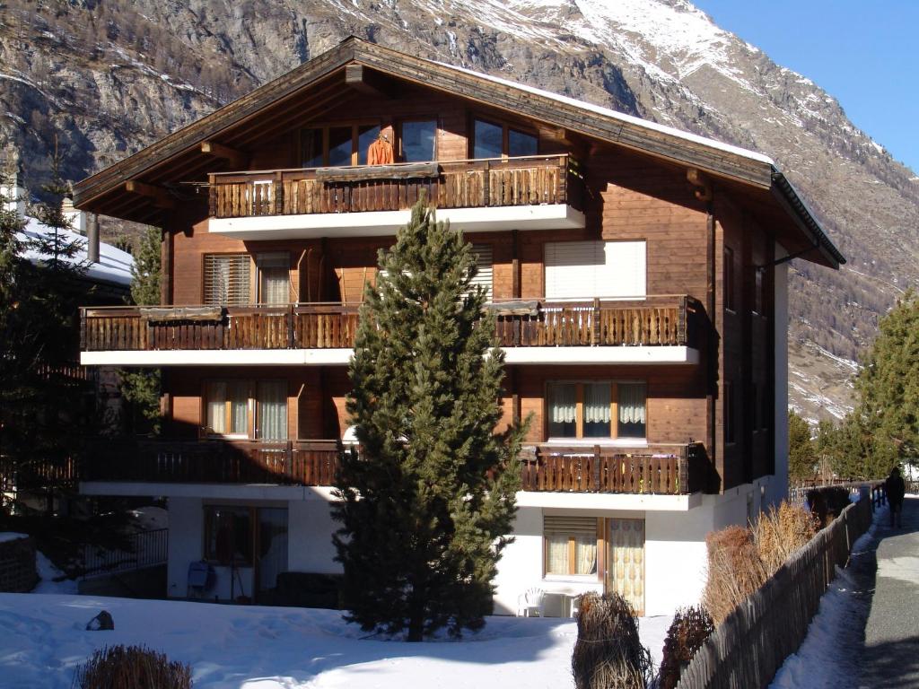 ein Gebäude mit einem Weihnachtsbaum davor in der Unterkunft Strahlhorn in Zermatt