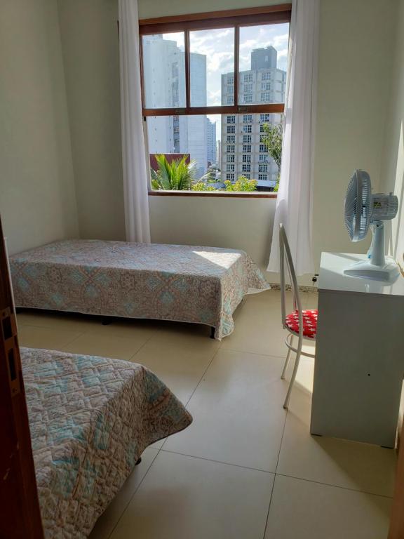 1 dormitorio con 2 camas y ventana grande en Espaço Inteiro para 08 pessoas próximo a área hospitalar em BH, en Belo Horizonte