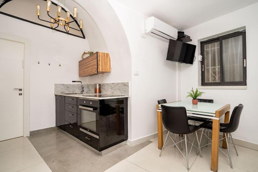 uma cozinha com um lavatório e uma mesa com cadeiras em Lovely 2 bedroom unit, Shivtey Israel, Jerusalem em Jerusalém