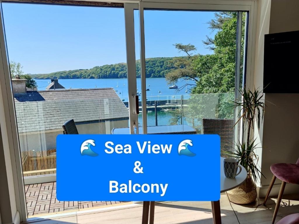 een bord voor een raam met uitzicht op een meer bij Crow's Nest Glandore - 1 - Self Catering in Glandore
