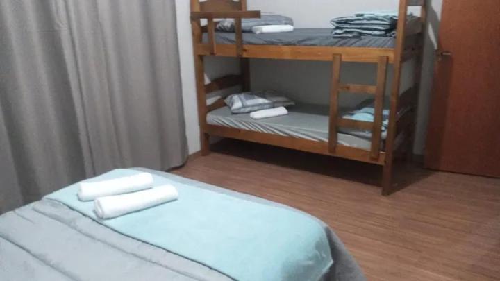una camera con un letto e una mensola con asciugamani di Nosso cantinho a Poços de Caldas