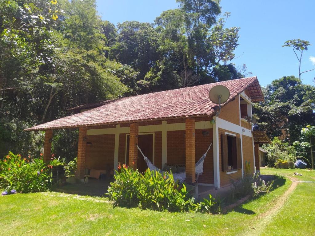 een klein huis met een dak op een grasveld bij Sítio Recanto Amado. in Santa Teresa