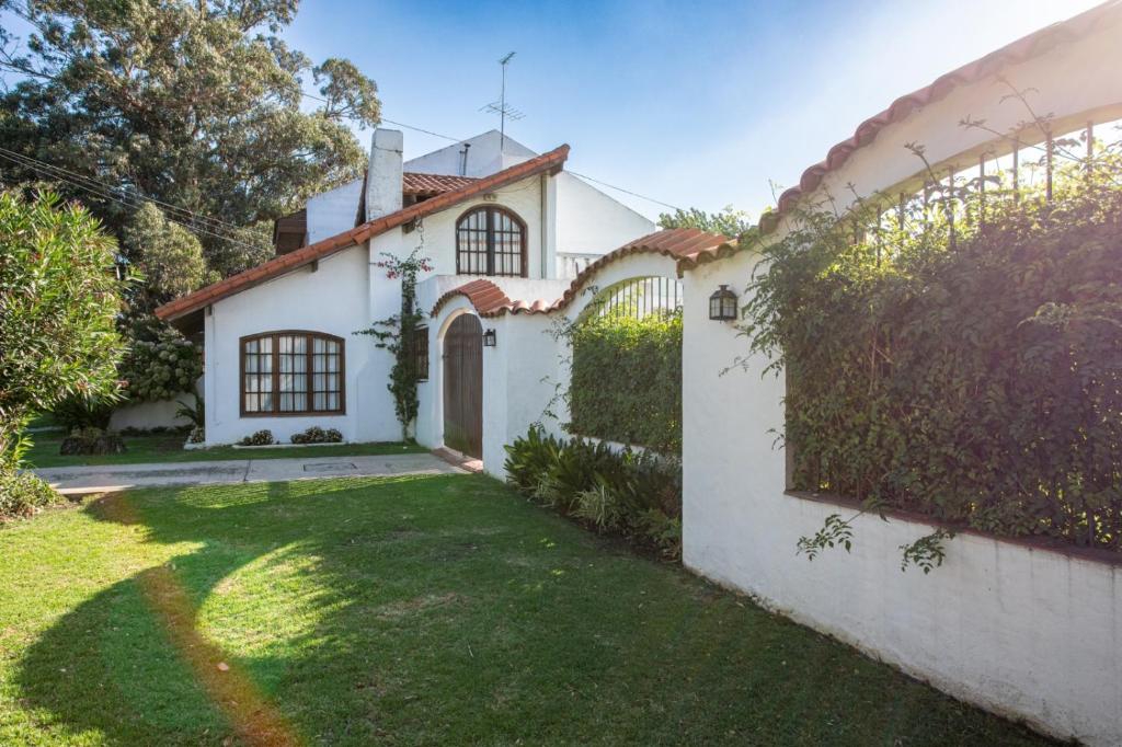 a white house with a green yard at Chalet en Barrio Parque in Mar del Plata