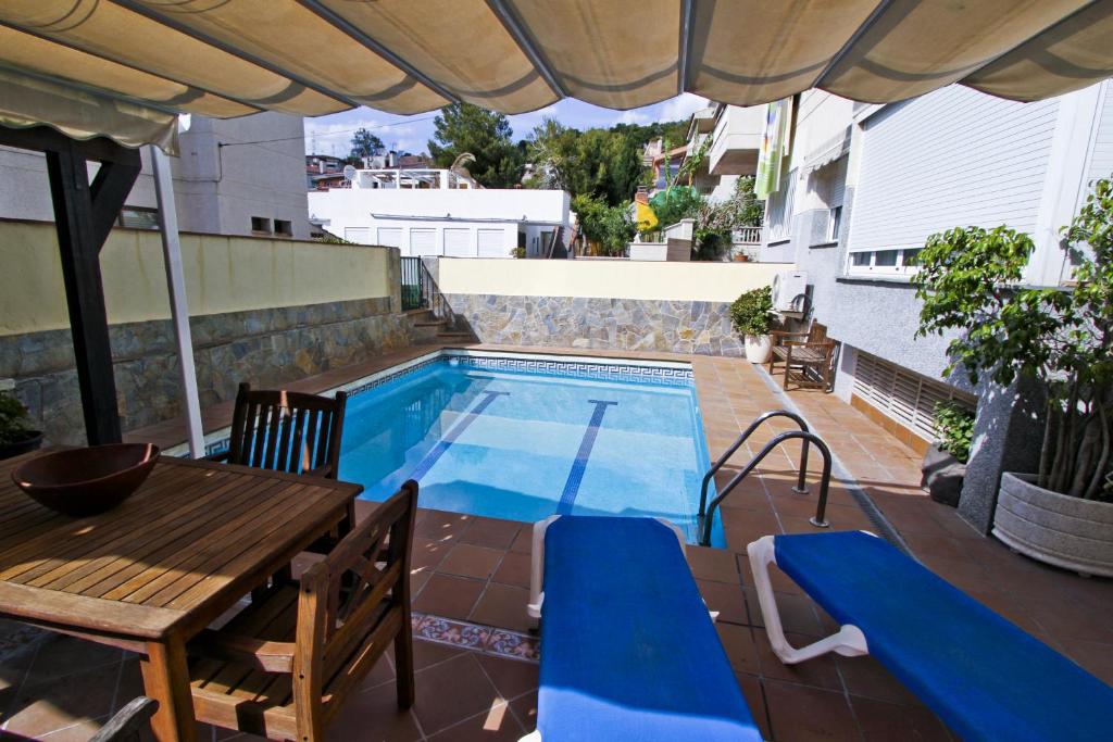 un patio con una mesa y una piscina en Buda Villa Planetcostadorada, en Salou